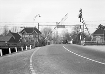 166519 Gezicht op de spoorwegovergang in de Van der Valk Boumanlaan te Woerden, met links het seinhuis.